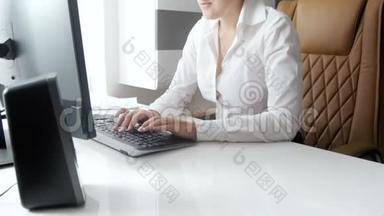 4K画面，美丽的微笑女商人坐在<strong>现代</strong>的白色<strong>办公桌</strong>后面，用电脑工作